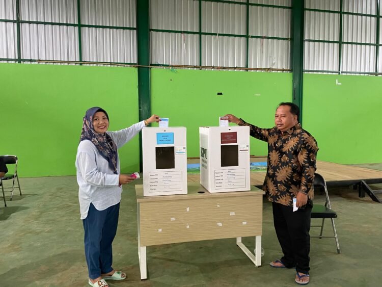 Madri Pani Di Dampingi Istri Gunakan Hak Pilih Nya Di TPS 02 Kampung Gurimbang